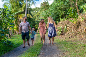 Family of four with mom, dad, daughter and son walking in the rain forrest